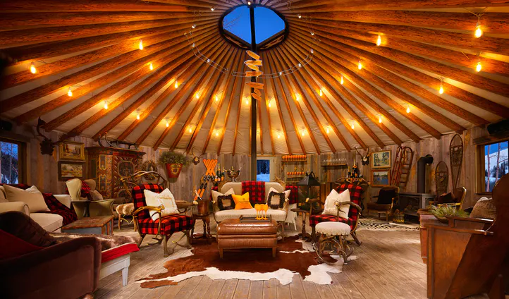 Cozy yurt with rustic decor and warm lighting.